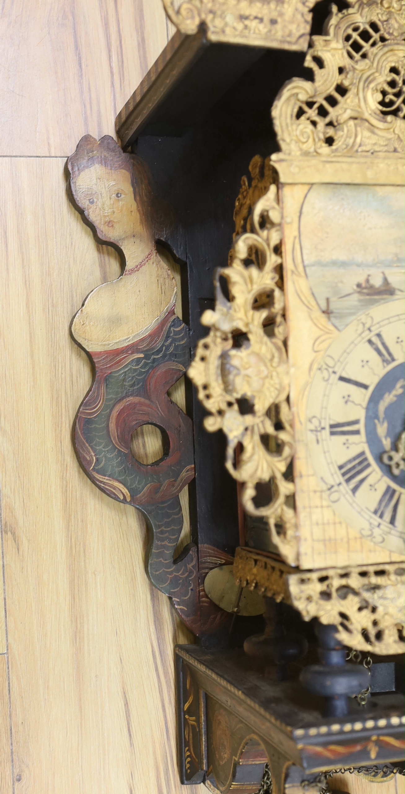 A decorative Dutch wall clock, with shaped painted mermaid side panels,72cm high